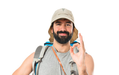 Backpacker making Ok sign over white background