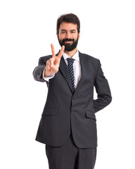 Businessman doing victory gesture over white background