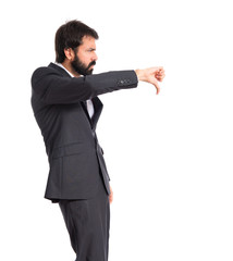 Businessman doing a bad signal over white background