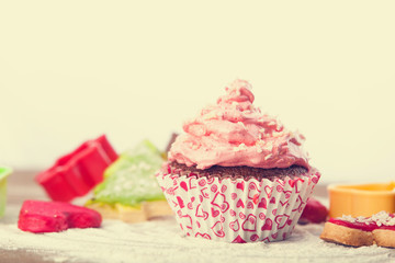 Cupcake with pink cream on a table.