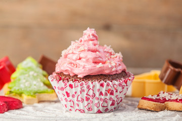 Cupcake with pink cream on a table.