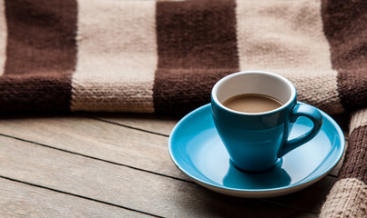 Cup with coffee and shape of the cacao heart on it and scarf.