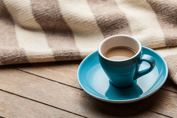 Cup with coffee and shape of the cacao heart on it and scarf.