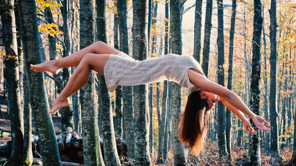 Levitation portrait of young beautiful woman in the woods. - obrazy, fototapety, plakaty