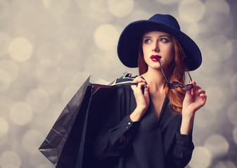 Style redhead girl with shopping bags.