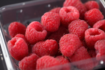 Fresh raspberries in plastic container