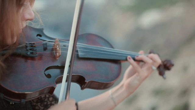 Beautiful violinist plays outdoors