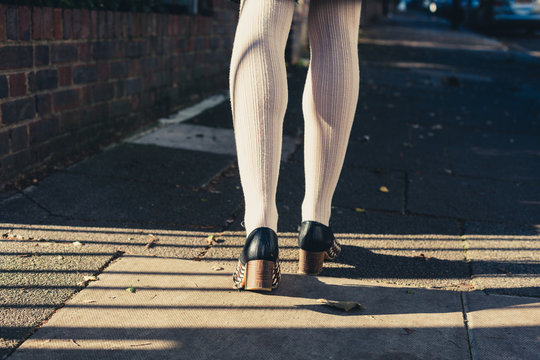 The legs of a woman walking in the street