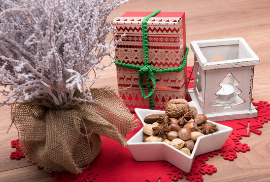 tree, candle holder, xmas present and bowl full of nuts.