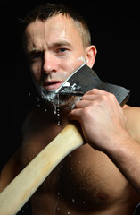 Bearded young man shaving with big axe foam and water splashes