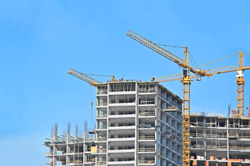 Crane and building construction site against blue sky
