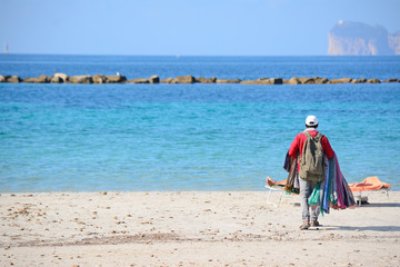 seller walking on the beach in Alghero shore