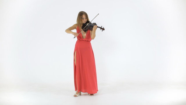 Concentrated violinist in a long dress plays her a musical