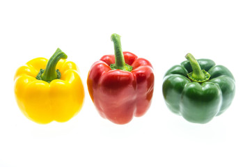 Red,green and yellow bell peppers on white background