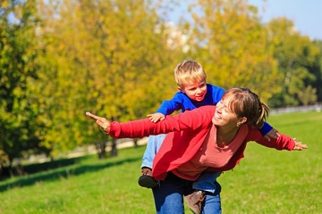 mother and son flying in autumn park