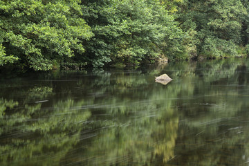 Fototapeta na wymiar Landscape long exposure of river flowing through lush green fore