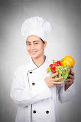Woman chef holding bowl of fresh vegetables