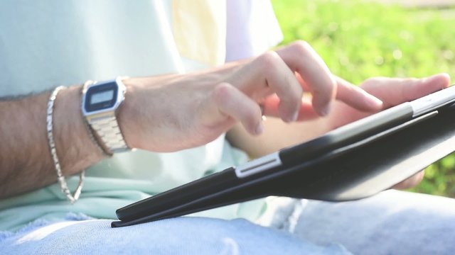 close up of man hands using tablet outdoor