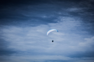 Paraglider soaring in the stormy sky 