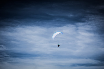 Paraglider soaring in the stormy sky 