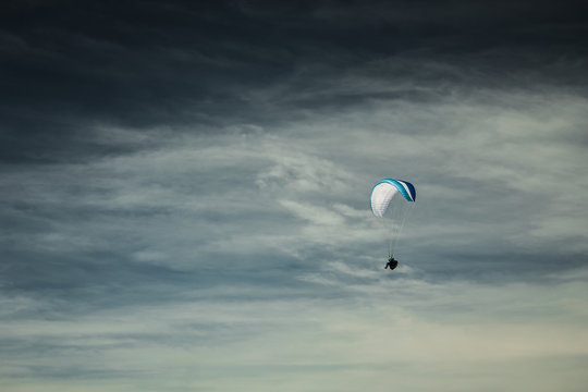 Paraglider soaring in the stormy sky 