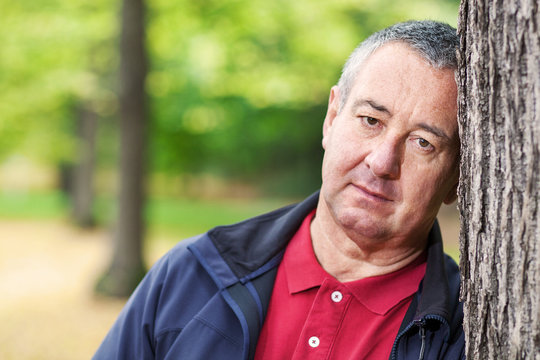 Emotion Loser man leaning against tree