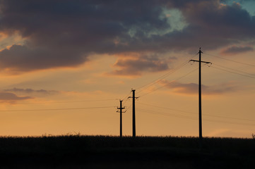 Fototapeta na wymiar sunset and three electric pylons