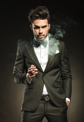 Fototapeta premium Elegant business man holding a cigarette in his right hand.