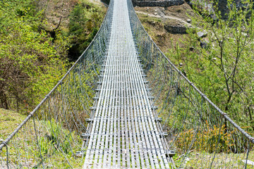 Suspension bridge. Annapurna Circuit - turists trek in Himalayas