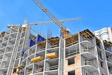Crane and building construction site against blue sky