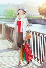 Beautiful girl with shopping bags talking on the mobile phone