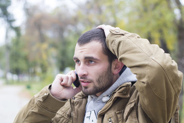 Young  worried man talking on phone