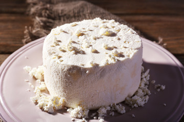 Cottage cheese on plate on sackcloth napkin on wooden