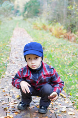 kid sitting forest road fall season clothes