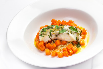 Seafood with pumpkin garnish. White diet  fish with pumpkin and