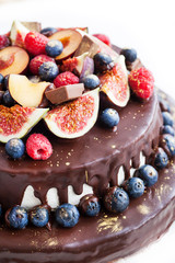 Chocolate cake with icing, decorated with fresh fruit