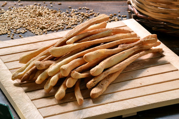 Grissinis, palillos de pan en ambiente rústico.