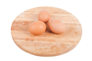Three eggs on a wooden board isolated on white background