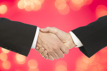 business handshake and people on red bokeh light background.