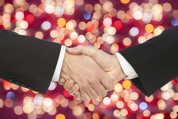 business handshake on multicolor bokeh light background.