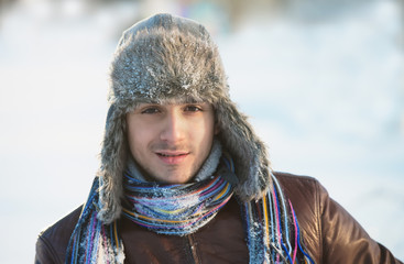 Portrait of a smiling young man in an ear flap hat