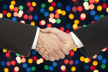 business handshake on multicolor bokeh light background.