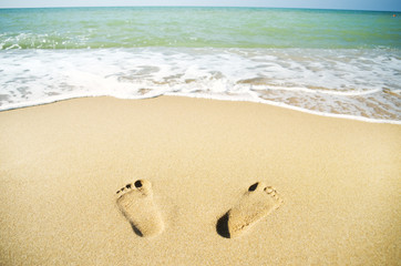 Footprints on the beach sand.