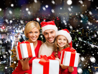 Fototapeta na wymiar happy family in santa helper hats with gift boxes