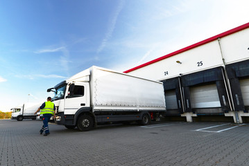 Unloading cargo trucks at warehouse building