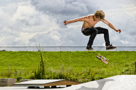 boy doing skateboard trick in skate park