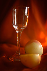 Glass and apples in front of a red cloth