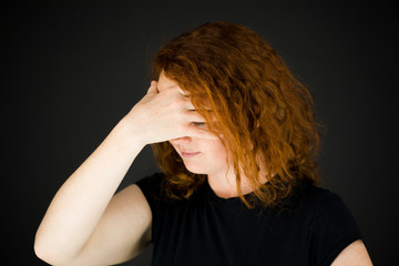 model isolated on plain background ashamed hiding face in hand