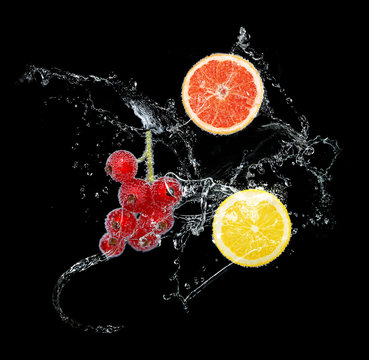 Fresh fruits in water splash, on black background