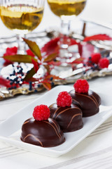 chocolate cake decorated with raspberries in white plate